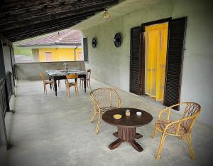a patio with a table and chairs on a porch at Casa Vacanze ai Valentini in Castelletto Soprano