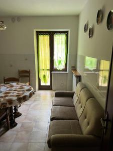 a living room with a couch and a table and a window at Casa Vacanze ai Valentini in Castelletto Soprano +19 photos