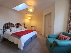 a bedroom with a bed and a chair and a window at Eden's House in Hexham