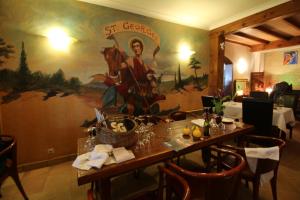 a dining room with a table and a painting on the wall at Auberge du col saint Georges in Grosseto-Prugna