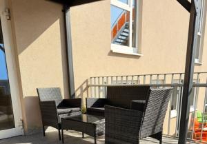 a patio with chairs and a table on a balcony at Hotel AVIVA by APOLONIA in Karlsruhe