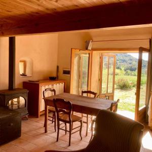 a dining room with a table and chairs and a fireplace at Le gîte de l'encantade in Trévillach
