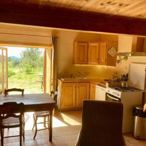 a kitchen with wooden cabinets and a table and a table and a tableablish at Le gîte de l'encantade in Trévillach