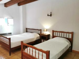 a room with two beds and a table with a lamp at Desix in Trilla