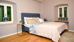 a bedroom with a blue bed and two windows at Villa Celine in Postira +43 photos