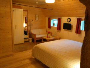 ein Schlafzimmer mit einem Bett und einem Stuhl in einem Zimmer in der Unterkunft B&B De Luttikhoeve in Giethmen