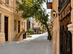 an empty street with a tree on the side of a building at Midway Park Hotel in Baku