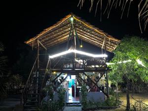 a house with a thatched roof at night at Sea secret in Arugam Bay