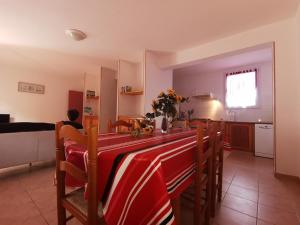 a dining room with a table and chairs and a kitchen at Lou soula in Trilla