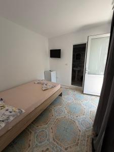 a bedroom with a bed and a room with a tv at Casa Raul Eforie Sud in Eforie Sud