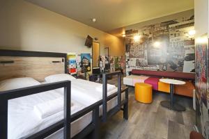 a room with two beds and a table in it at a&o Stuttgart City in Stuttgart +49 photos