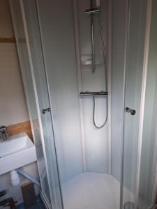 a shower with a glass door next to a sink at Slettavegen1a in Time +6 photos
