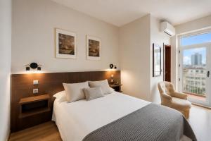a bedroom with a bed and a chair and a window at Hotel Vice-Rei in Porto