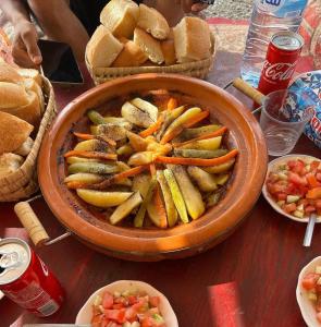 a table with a bowl of vegetables and bread at Maison-Lala Takerkoust et agafay in Lalla Takerkoust +7 photos