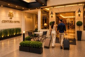a man and woman walking through a mall with luggage at Hotel Centuria Obelisco in Buenos Aires
