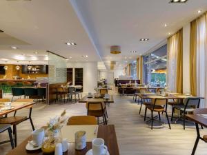 a restaurant with tables and chairs and a cafeteria at Mercure Aachen Europaplatz in Aachen
