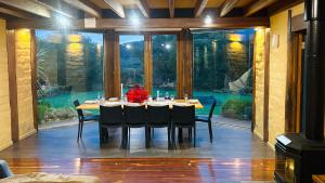 a dining room with a table and chairs and a large window at Moon light Retreat in Whittlesea