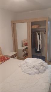 a bedroom with a white bed and a mirror at Stan in Bar
