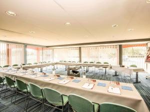 a large room with tables and chairs and windows at ibis Montélimar Nord in Saulce-sur-Rhône +105 photos