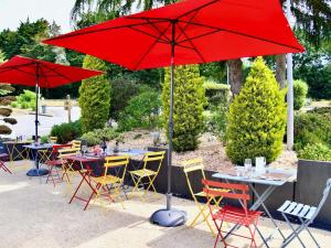 a group of tables and chairs with red umbrellas at ibis Quimper in Quimper