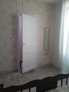 a white door in a room with a mirror at Joli hébergement indépendant in Lavelanet