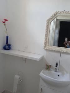 a white bathroom with a sink and a mirror at Joli hébergement indépendant in Lavelanet