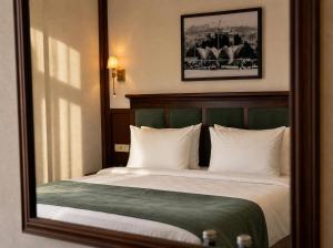 a bedroom with a bed with a large mirror at Midway Park Hotel in Baku