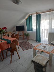 a living room with a table and a television at Szekrény Apartman in Lenti