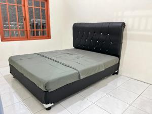 a black bed in a room with a window at Villa Kay Terrace in Campaka +8 photos
