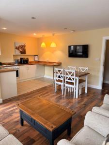 a kitchen and living room with a table and chairs at Causeway Lodge in Bushmills