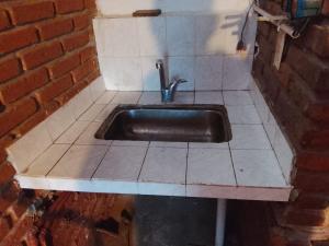 a kitchen with a sink on a tiled floor at alojamiento Villa sarita in Posadas