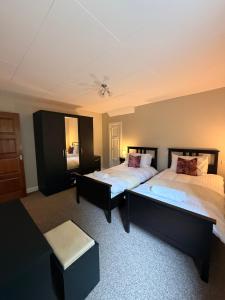 a bedroom with two beds and a stool in it at Causeway Lodge in Bushmills +15 photos