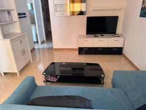 a living room with a tv and a coffee table at Chalet Calan Bosch in Cala en Bosc