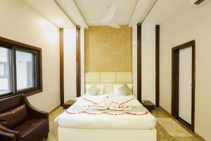 a hotel room with a bed and a chair at K2 Highway Treat & Resort Unit of Lyzon in Bhadaura