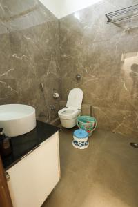a bathroom with a toilet and a sink at K2 Highway Treat & Resort Unit of Lyzon in Bhadaura +33 photos