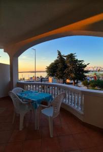 a table and chairs on a balcony with a view of the ocean at Villa Andale Suites in Tkon