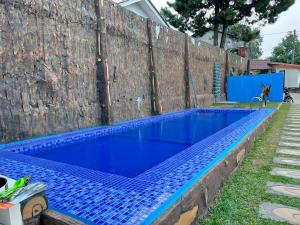 a blue swimming pool next to a wooden fence at Villa Kay Terrace in Campaka