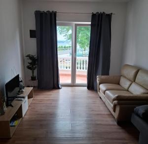 a living room with a couch and a sliding glass door at Villa Andale Suites in Tkon