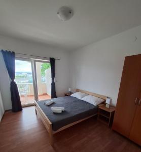 a bedroom with a bed and a large window at Villa Andale Suites in Tkon