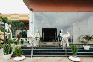 a group of white statues on the stairs of a building at K2 Highway Treat & Resort Unit of Lyzon in Bhadaura