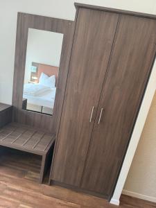 a large wooden wardrobe with a mirror in a bedroom at Hotel zur Post - Schrobenhausen in Schrobenhausen