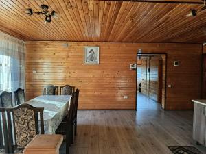 a dining room with a table and a wooden wall at День і ніч in Slavske