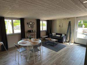 a living room with a table and chairs and a couch at CozyCocoon Appartement in Parcey