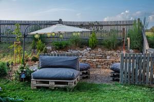 a yard with two chairs and an umbrella and a fence at Das Fichtelgut in Wunsiedel