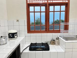 a kitchen with a black stove top on a counter at Villa Kay Terrace in Campaka