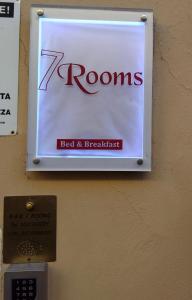 a sign on a wall with a z rooms bed and breakfast at B&B 7 Rooms in Pisa