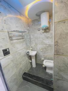 a bathroom with a toilet and a sink at Radhika Cozy Studio Apartment Kitchen 2 Double Beds in Vrindāvan