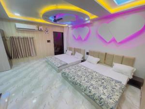 two beds in a room with a purple ceiling at Radhika Cozy Studio Apartment Kitchen 2 Double Beds in Vrindāvan
