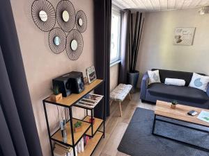 a living room with a blue couch and mirrors on the wall at CozyCocoon Appartement in Parcey