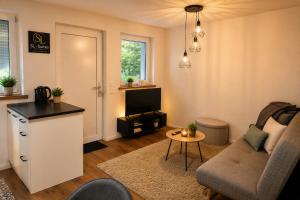 a living room with a couch and a table at Neues 2 Zimmer Schmuckstück in Ergetsweiler